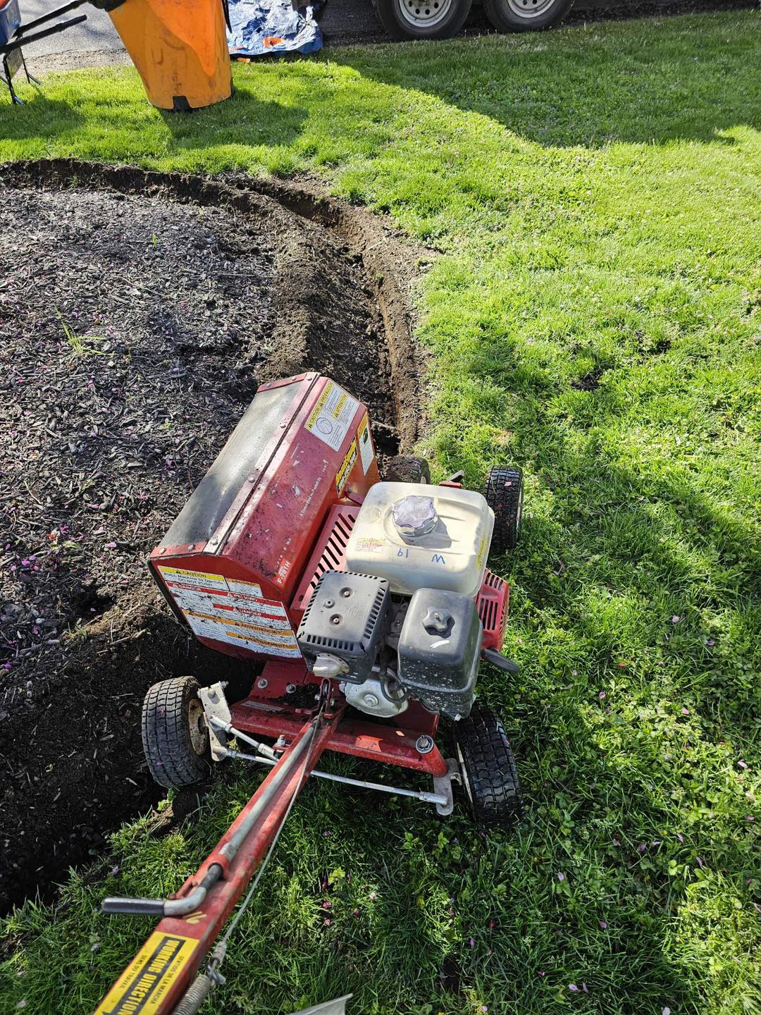 Bed edger cutting a crisp trench between lawn and mulch bed